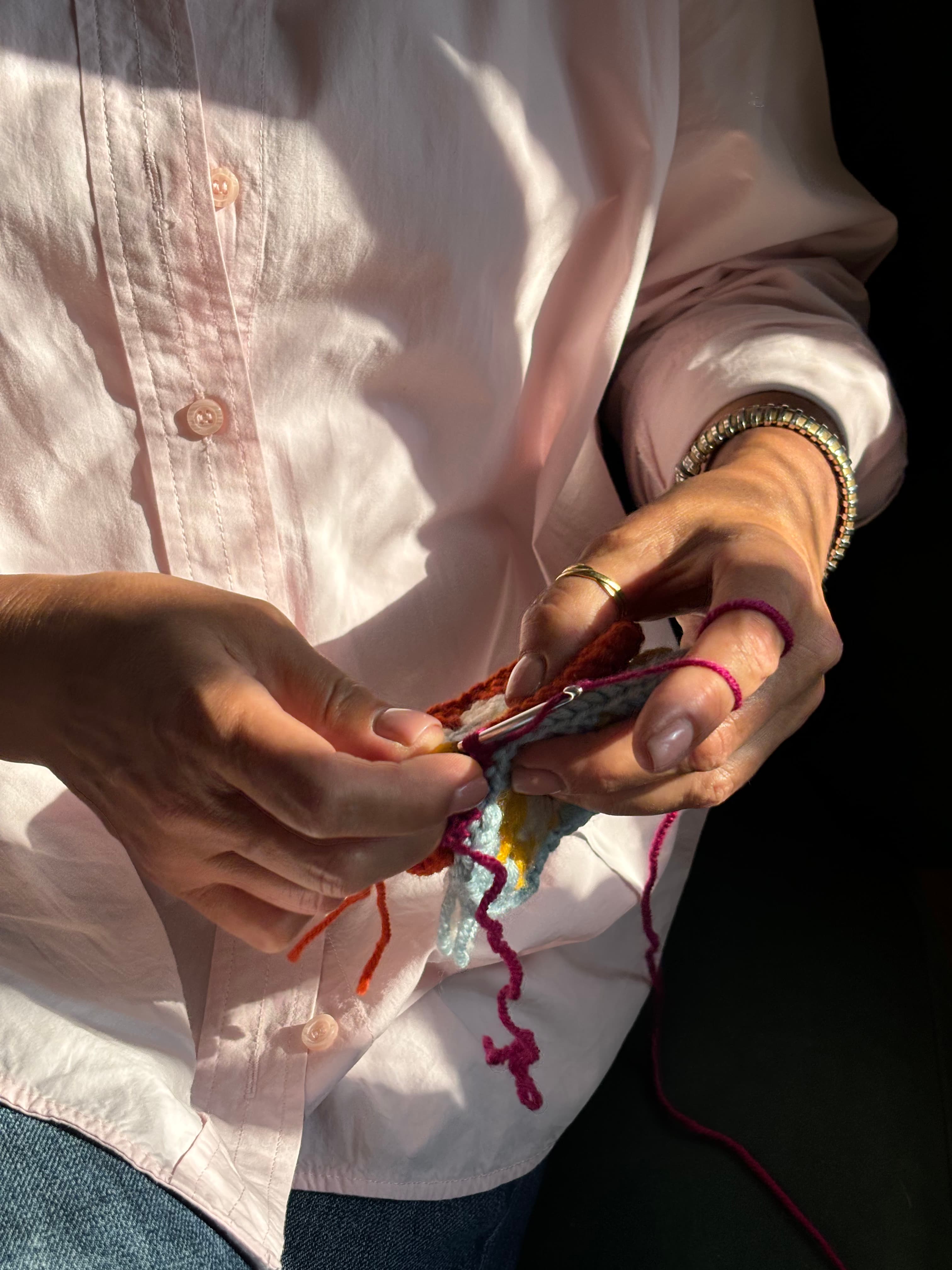 Artisan hands crocheting colorful wool